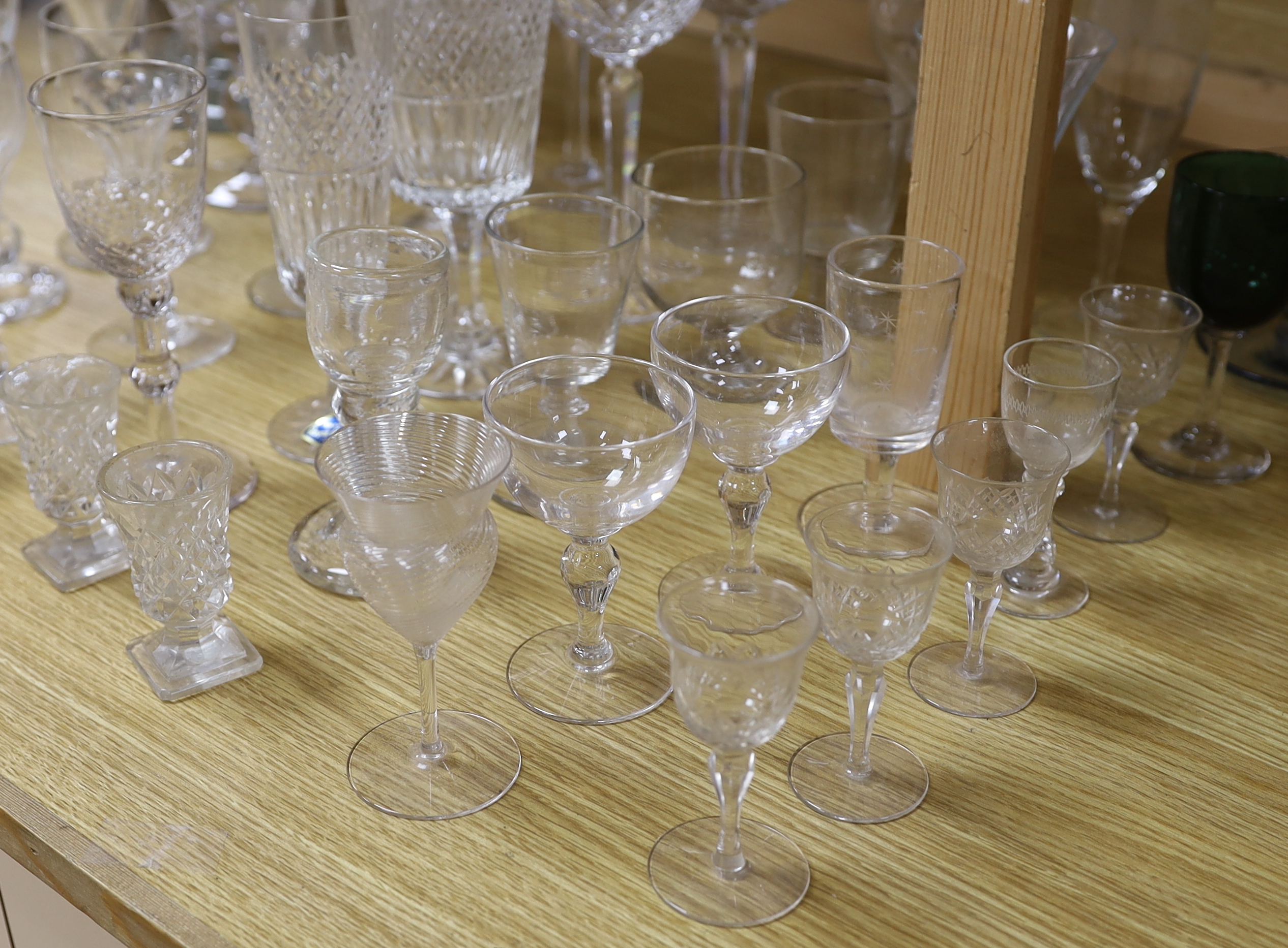 A large glass centrepiece, a teardrop trumpet shaped vase and a collection of 19th and 20th century wine and other drinking glasses